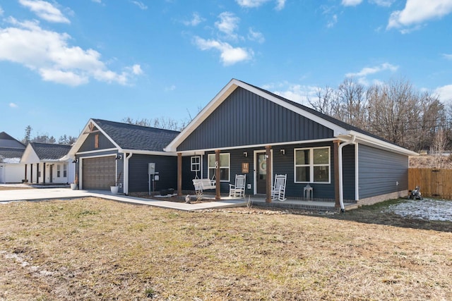 view of front of house featuring a garage, a porch, and a front lawn