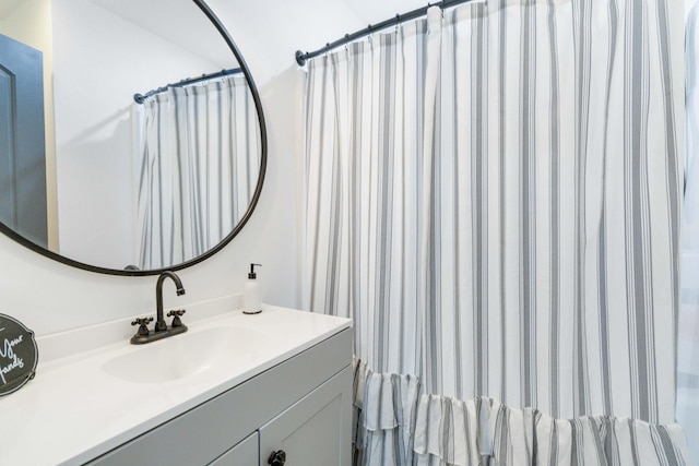 bathroom featuring walk in shower and vanity