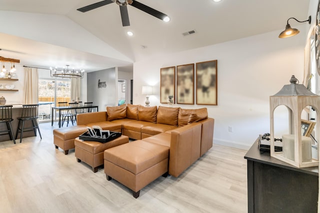 living room with lofted ceiling, ceiling fan with notable chandelier, and light wood-type flooring