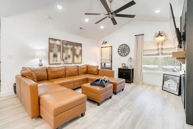 living room with light hardwood / wood-style flooring, ceiling fan, and vaulted ceiling