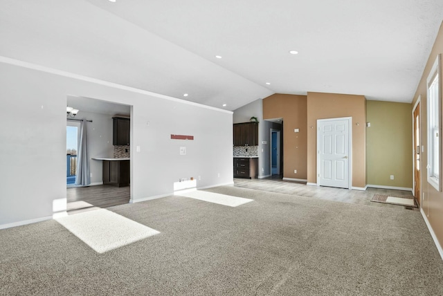 unfurnished living room featuring lofted ceiling and light carpet