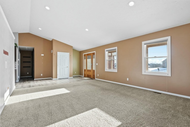 unfurnished living room featuring lofted ceiling and light colored carpet