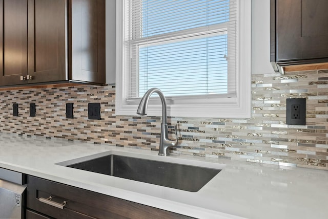 kitchen with tasteful backsplash, dark brown cabinets, and sink