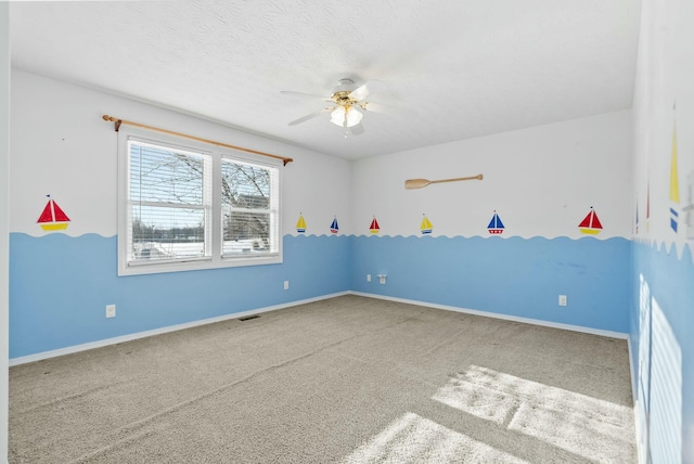 carpeted empty room featuring ceiling fan and a textured ceiling