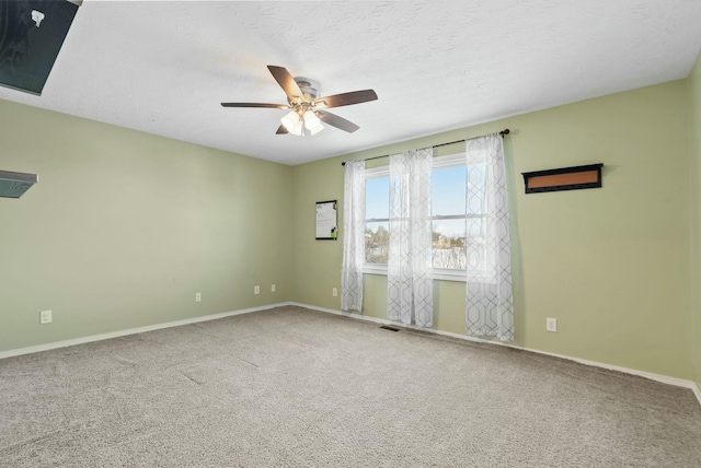 carpeted spare room with a textured ceiling and ceiling fan