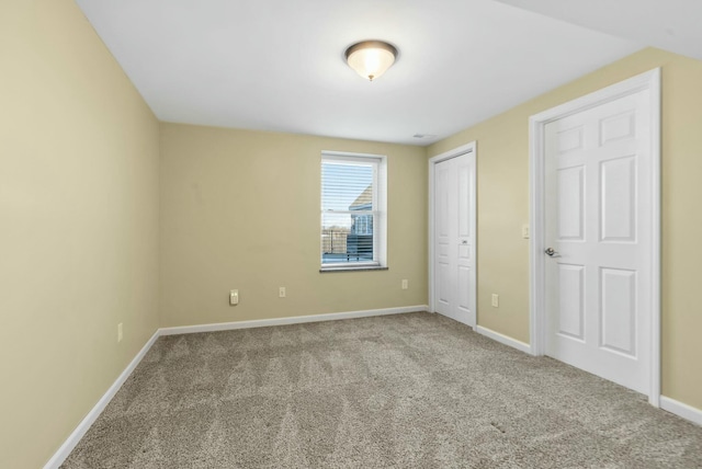 unfurnished bedroom with light colored carpet and a closet