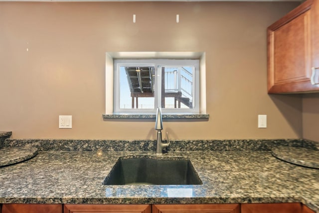 kitchen featuring dark stone countertops and sink