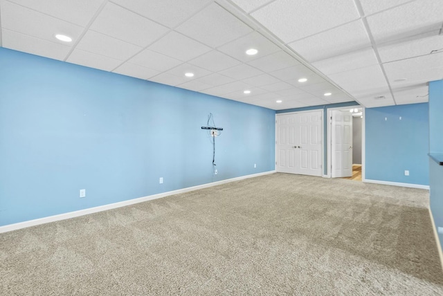 basement featuring carpet and a drop ceiling