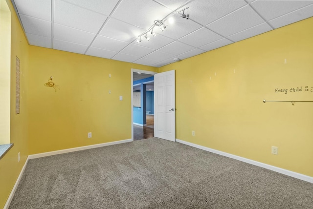 spare room with carpet floors and a drop ceiling