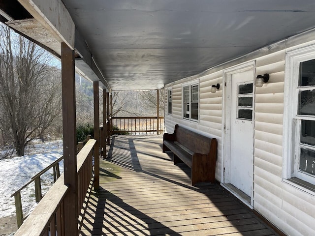 snow covered deck with a porch