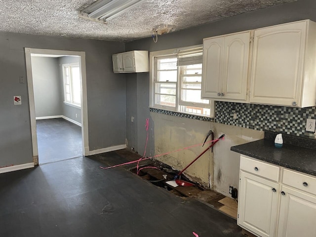 kitchen featuring a textured ceiling, decorative backsplash, and white cabinets