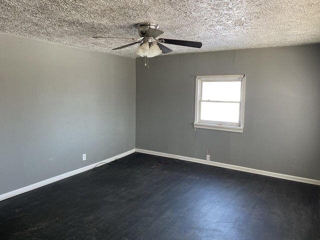 empty room featuring dark wood-type flooring, ceiling fan, and a textured ceiling