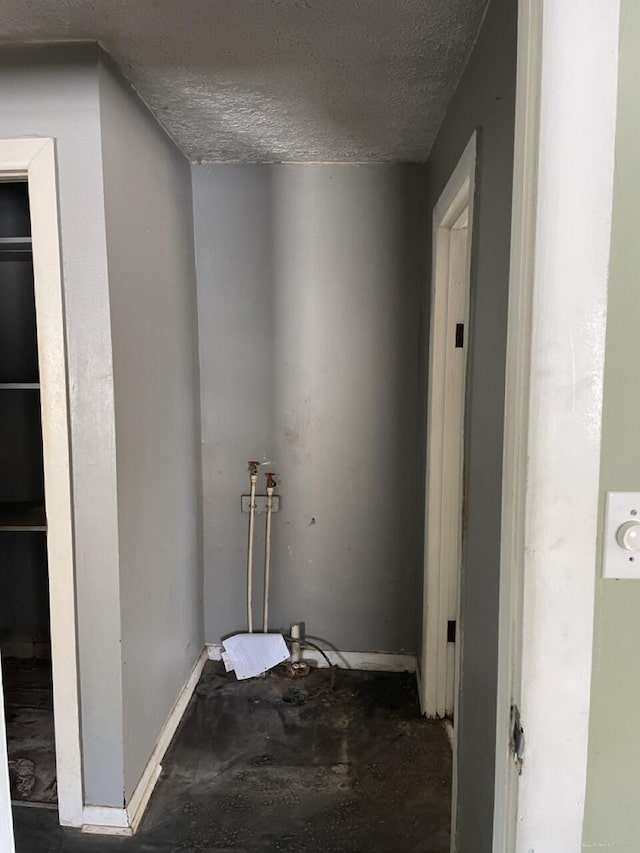 clothes washing area with a textured ceiling