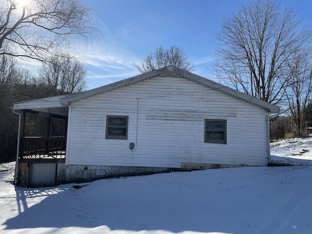 view of snowy exterior featuring covered porch