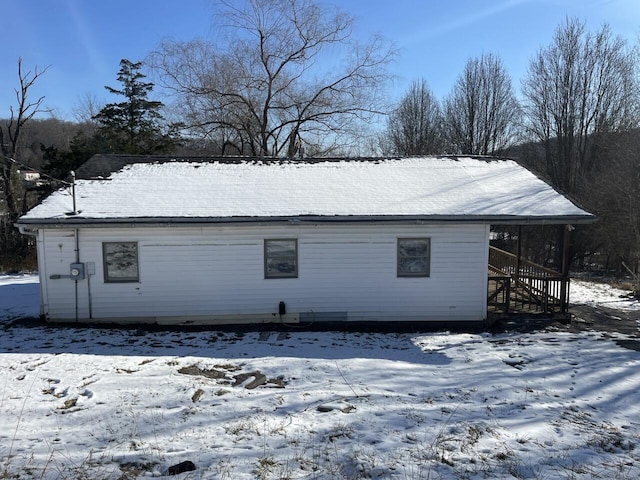 view of snow covered back of property