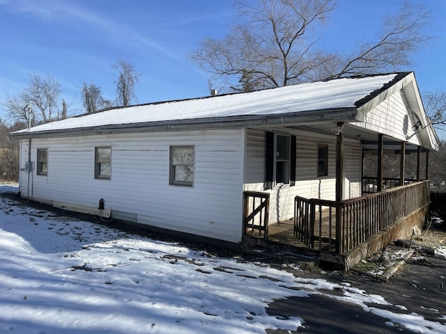 view of snow covered exterior featuring a porch