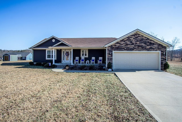 ranch-style house featuring a garage, a porch, and a front lawn