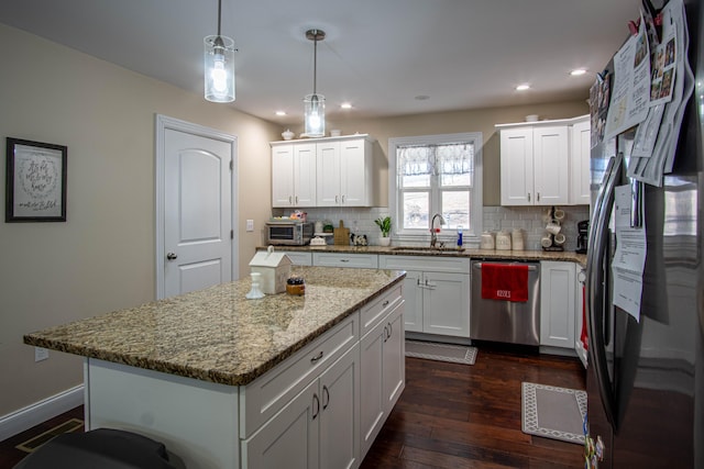 kitchen featuring sink, a center island, black refrigerator, dishwasher, and white cabinets