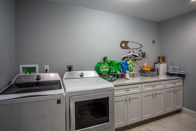 laundry area with cabinets, light tile patterned flooring, and washer and dryer