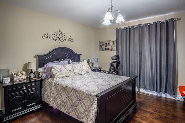 bedroom with an inviting chandelier and dark hardwood / wood-style flooring