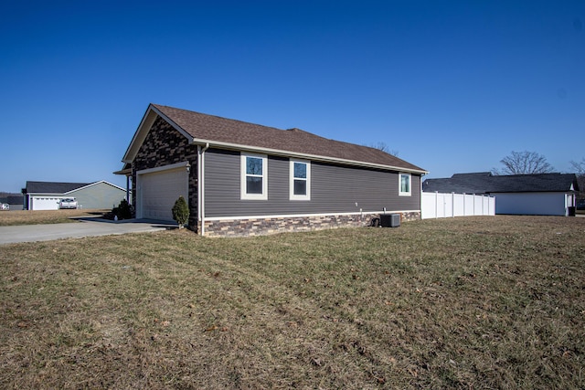 view of home's exterior with a garage, a yard, and central AC