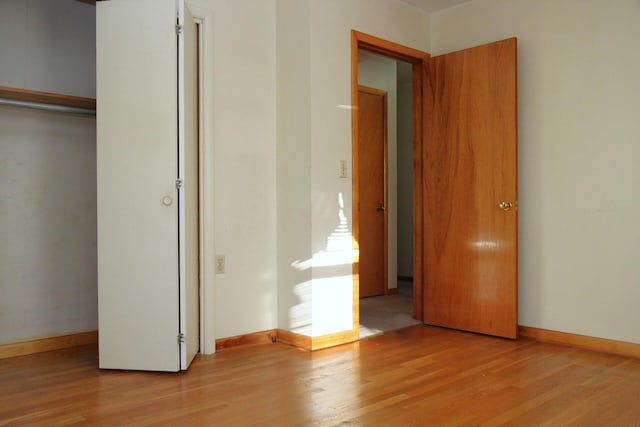 unfurnished bedroom featuring light wood-type flooring and a closet