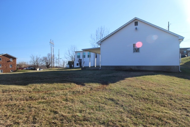 view of side of home with a yard