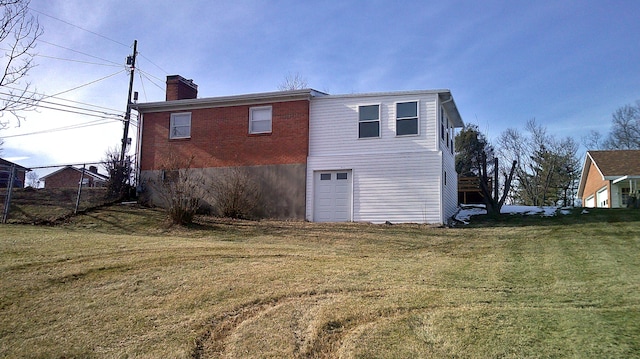 rear view of property featuring a yard and a garage