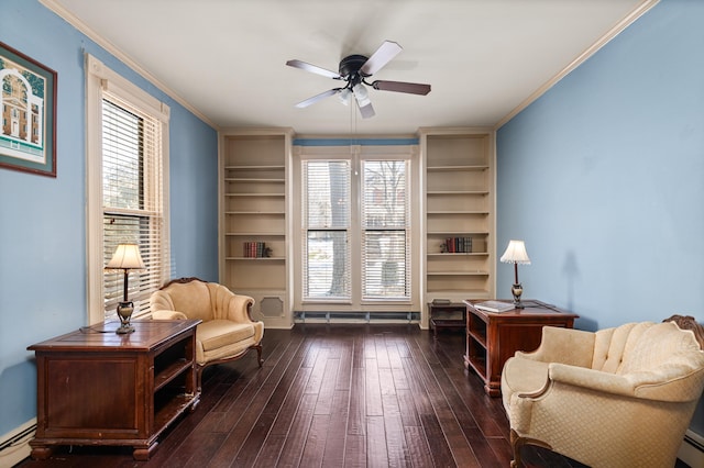 living area featuring built in features, dark hardwood / wood-style flooring, ceiling fan, baseboard heating, and crown molding