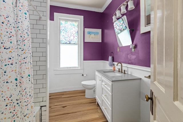 full bathroom featuring toilet, wood-type flooring, ornamental molding, shower / bathtub combination with curtain, and vanity