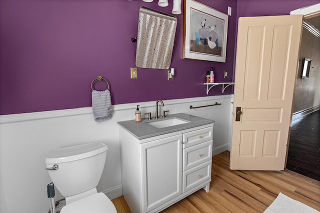 bathroom with vanity, toilet, and hardwood / wood-style floors