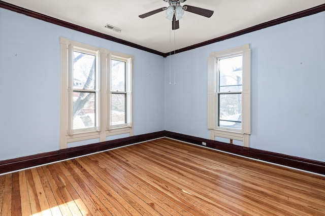 unfurnished room with ceiling fan, ornamental molding, wood-type flooring, and plenty of natural light