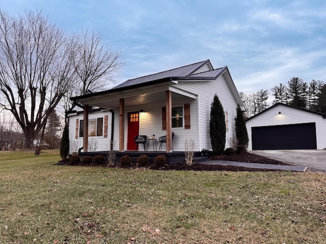 view of front of property with a porch, a garage, an outdoor structure, and a front lawn