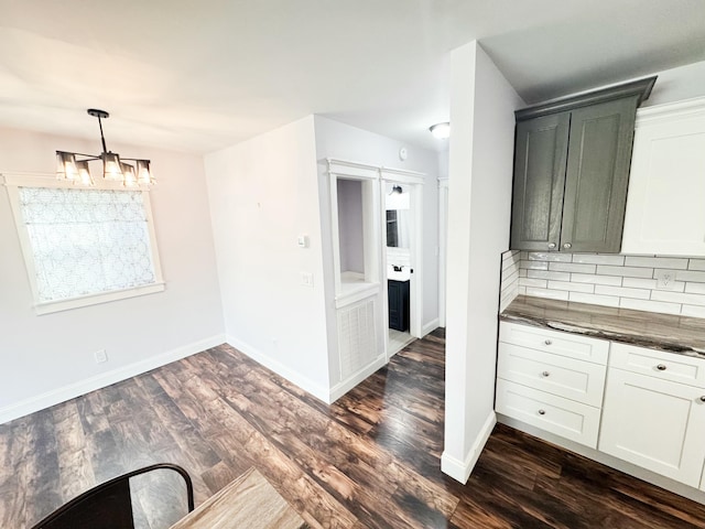 unfurnished dining area with dark hardwood / wood-style floors and a notable chandelier