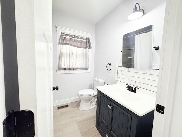 bathroom featuring hardwood / wood-style floors, a shower with shower curtain, tasteful backsplash, vanity, and toilet