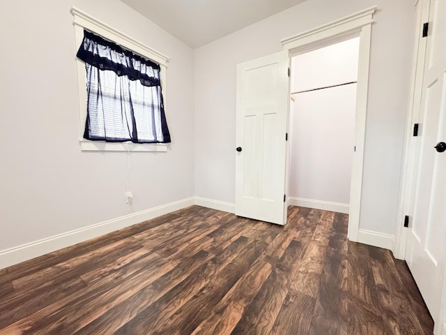 unfurnished bedroom featuring dark wood-type flooring and a closet