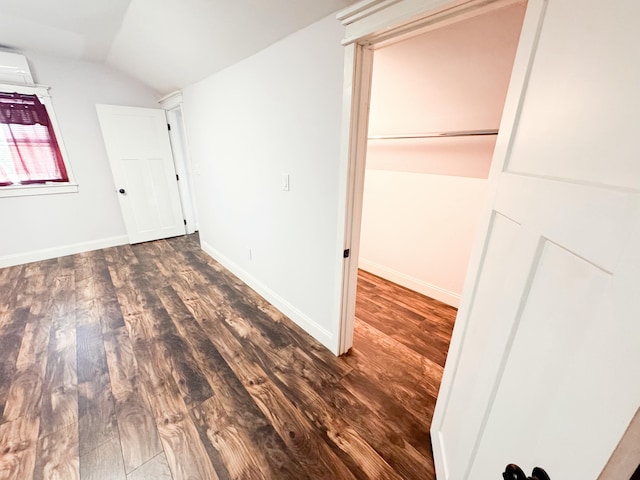 unfurnished bedroom featuring lofted ceiling and dark hardwood / wood-style flooring