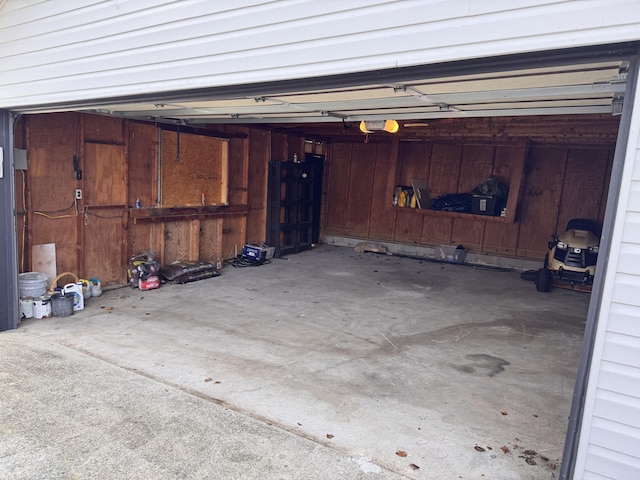 garage featuring a garage door opener and wood walls