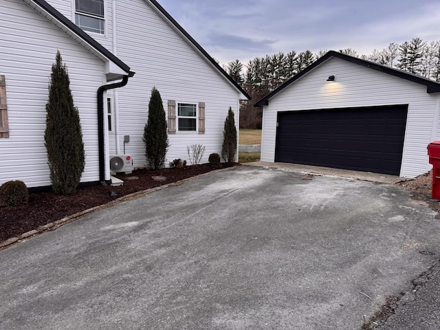 view of home's exterior featuring a garage, ac unit, and an outbuilding