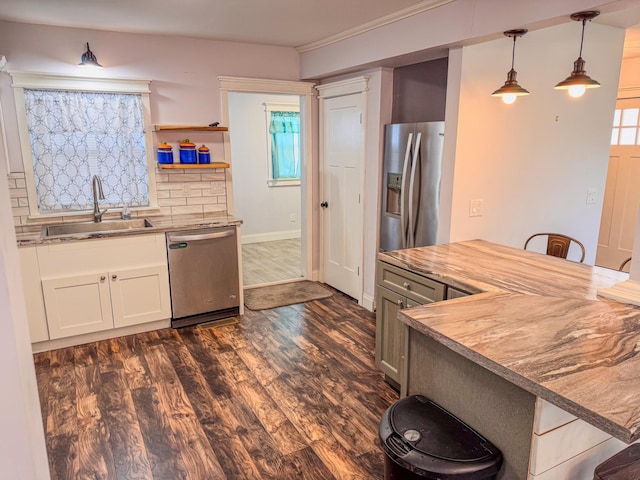 kitchen featuring sink, a breakfast bar area, white cabinetry, hanging light fixtures, and stainless steel appliances