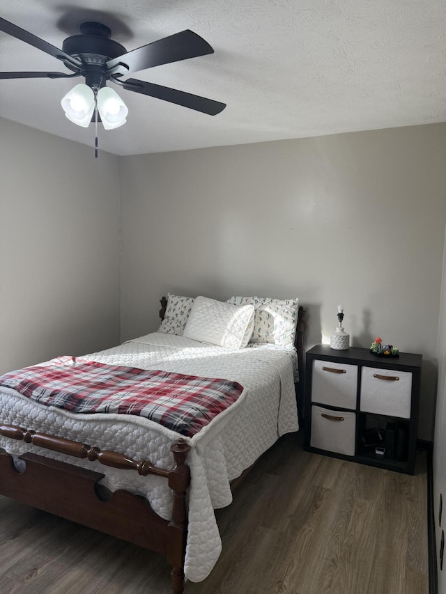 bedroom with dark hardwood / wood-style flooring and ceiling fan