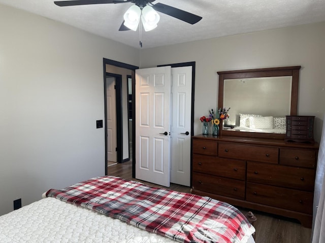 bedroom featuring ceiling fan, dark hardwood / wood-style floors, and a closet