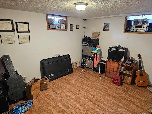 playroom featuring a textured ceiling and light wood-style flooring