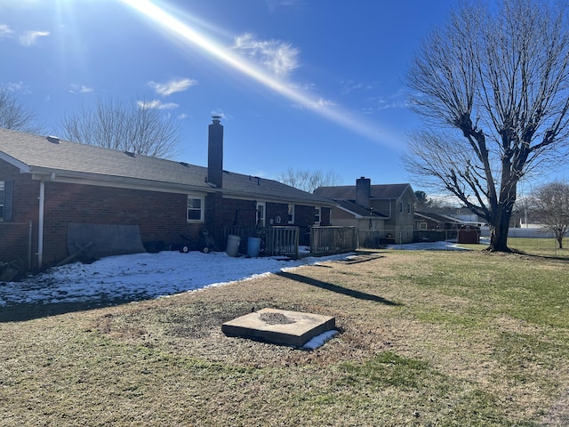 back of property featuring brick siding and a lawn