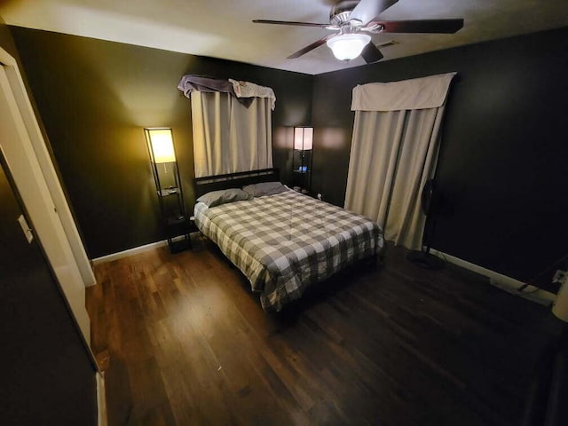 bedroom with dark hardwood / wood-style flooring and ceiling fan