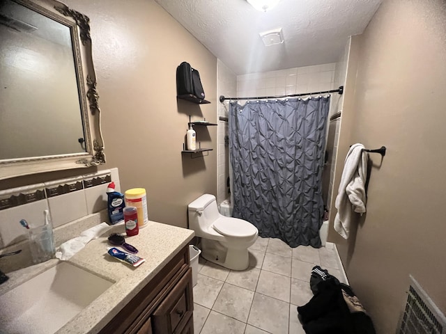 full bathroom featuring tile patterned floors, toilet, a textured ceiling, vanity, and shower / bath combo with shower curtain