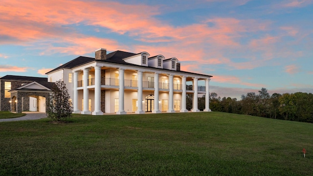 exterior space with a balcony and a lawn