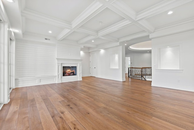 unfurnished living room featuring beamed ceiling, coffered ceiling, and light hardwood / wood-style floors