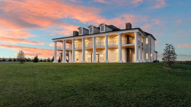 exterior space featuring a balcony and a lawn