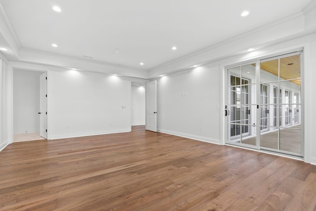 empty room featuring crown molding and wood-type flooring